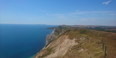 Depicts an almost cloudless blue sky above the rugged cliffs of the Jurassic Coast Path, Dorset, UK