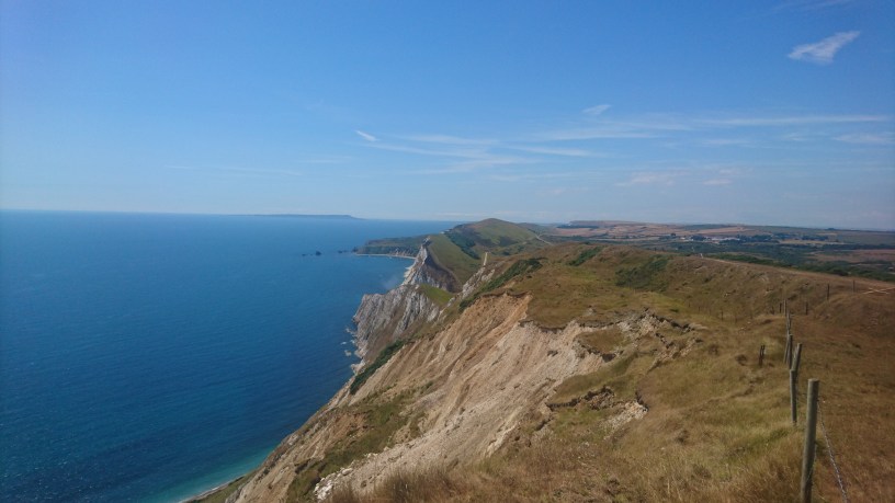 Depicts an almost cloudless blue sky above the rugged cliffs of the Jurassic Coast Path, Dorset, UK