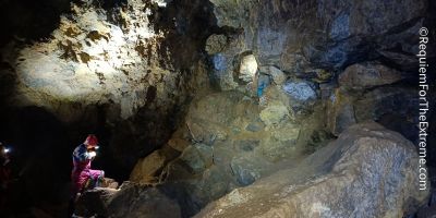 A lone caver checks his watch in one of the larger chambers of Wapping mine, Matlock Bath. Huge boulders are scattered around.