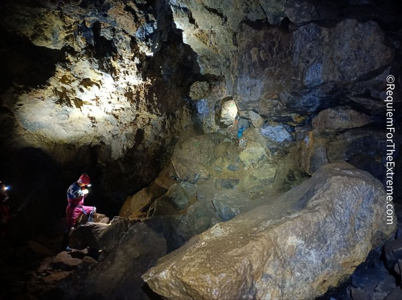 A lone caver checks his watch in one of the larger chambers of Wapping mine, Matlock Bath. Huge boulders are scattered around.
