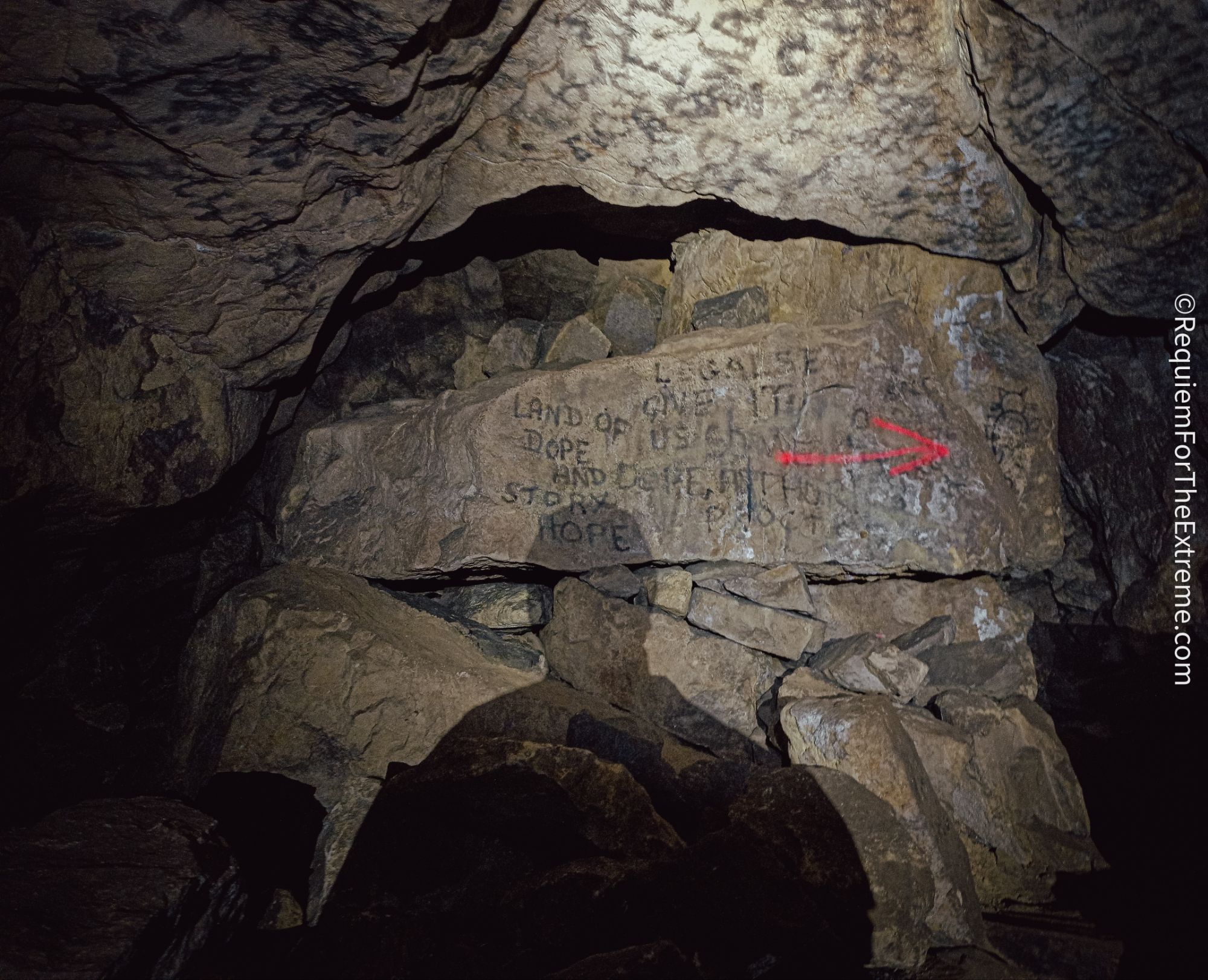 Shadow of a Caver in front of some of the Graffiti in Cumberland Cavern Matlock Bath also known as 'The Troggs Cave' the words 'Legalise It' and 'Land of dope and story' can be read written in campfire soot